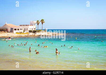 TORREVIEJA, ESPAGNE - 13 septembre 2014 : Soleil plage Méditerranéenne, les touristes se détendre sur le wave. Les gens se baignent dans l'eau cristalline Banque D'Images