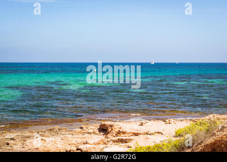 Voilier flottant dans la mer sur la côte de la pierre, de l'horizon de Sunny Beach, Av de la Purisima, Torrevieja, Communauté Valencienne, Espagne Banque D'Images