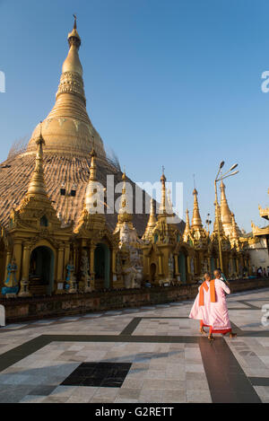 Deux nonnes bouddhistes à pied par la pagode Shwedagon, Yangon, Myanmar. Banque D'Images