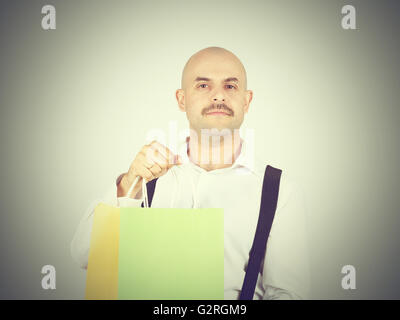 Caucasian man chauve, avec des sacs en papier colorées isolé sur fond. Banque D'Images