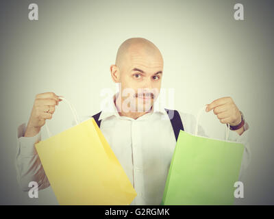 Caucasian man chauve, avec des sacs en papier colorées isolé sur fond. Banque D'Images