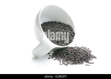 Graines de sésame noir. Des graines de sésame dans le bol isolé sur fond blanc. Banque D'Images