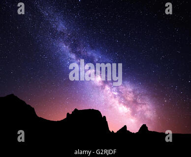 Paysage de nuit avec Voie Lactée et colorés à la lumière jaune des montagnes. Ciel étoilé avec des pierres à l'été. Bel Univers Banque D'Images