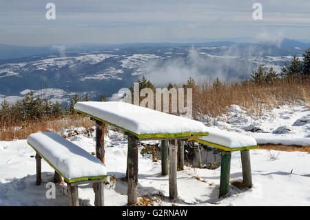 La neige a couvert deux vieux bancs en bois et une table, ensoleillée journée d'hiver de la Montagne Vitosha, large vue panoramique Banque D'Images