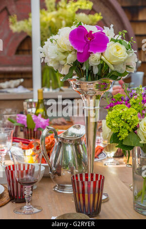 Table élégante pour un déjeuner en plein air avec de l'argent et des fleurs fraîches Banque D'Images