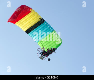 Parapente powered volant sous ciel bleu clair Banque D'Images