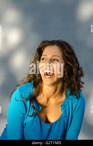 Studio portrait of mid age Hispanic woman laughing Banque D'Images