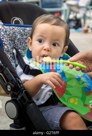 Baby Boy eating dans une poussette dans le parc Banque D'Images