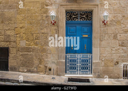 La porte bleue - l'entrée dans une vieille maison en pierre. Lanternes décoratives avec l'assiette de la croix de Malte. Seglea, île de Malte. Banque D'Images