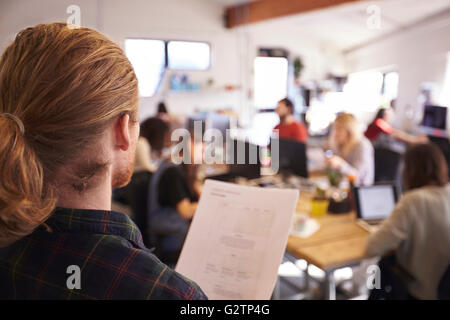 Designer à la recherche dans le document au Bureau actif Banque D'Images