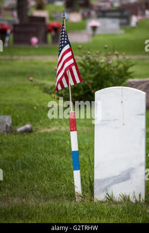 Vu de derrière, une pierre tombale en marbre massif, avec un drapeau américain à côté de l'identifier comme un vétéran militaire's grave. Banque D'Images