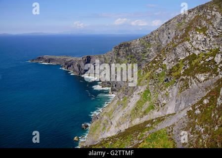 L'Irlande, le comté de Kerry, l'île de Valentia, vue en direction de la péninsule de Dingle de montagne Geokaun Parc avec falaises Fogher en premier plan. Banque D'Images