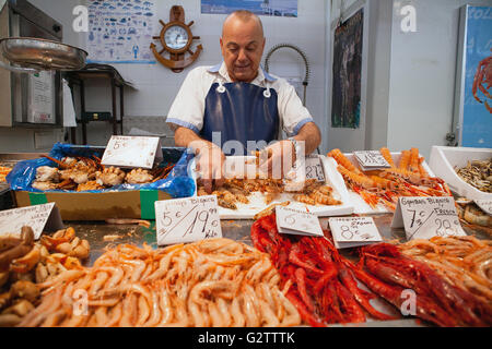 Espagne, Andalousie, Cadix, un poissonnier prépare une commande de langoustines à son échoppe au marché central. Banque D'Images