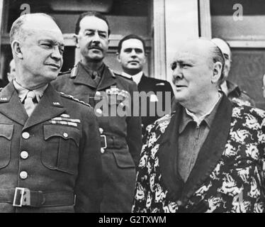 Le Premier ministre britannique Winston Churchill (à droite), portant son fameux costume de sirène, et une robe de couleur, comme il a conféré avec le général Dwight D. Eisenhower (à gauche), récemment nommé commandant en chef des forces alliées de l'invasion européenne. Dans le centre est le général sir Harold Alexander, commandant en chef des forces alliées en Italie. Churchill a récemment récupéré d'une pneumonie. Banque D'Images