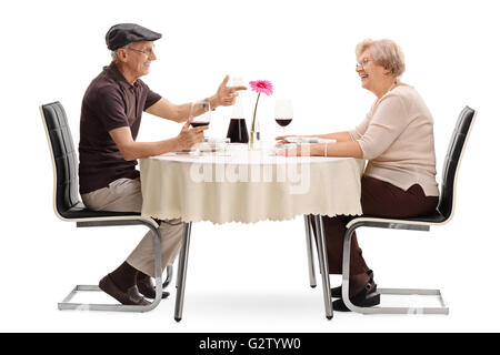 D'âge mûr se parler assis à une table romantique sur une date isolé sur fond blanc Banque D'Images