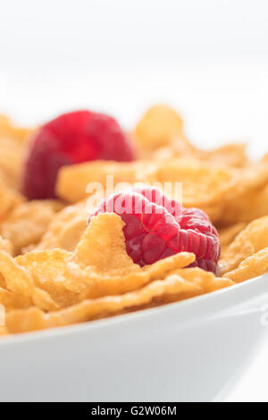 A proximité de l'uop cornflakes et framboise dans un bol blanc. Banque D'Images