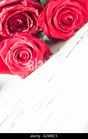 Roses rouges portant sur une table en bois rustique. Banque D'Images