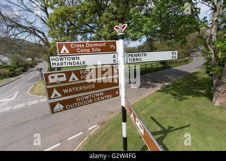 Pooley Bridge, Angleterre. Vue pittoresque sur un panneau routier fingerpost avec Pooley Bridge High Street, dans l'arrière-plan. Banque D'Images