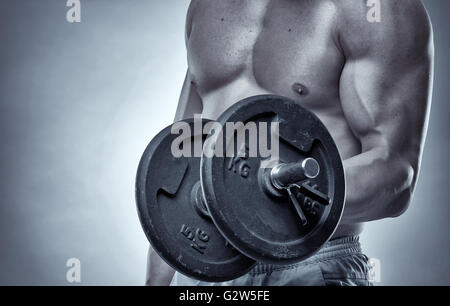 Faire de l'athlète avec haltères curl biceps, studio shot Banque D'Images