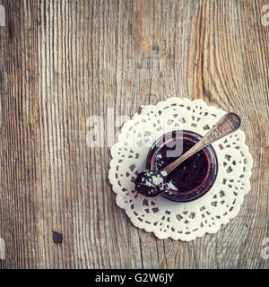 Cuillère à pot de confiture sur la vieille table en bois. Vue d'en haut. Banque D'Images