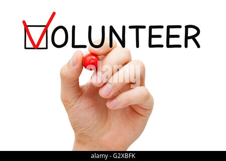 Mettre la main coche avec marqueur rouge sur la case à cocher dans le formulaire de bénévolat. Banque D'Images