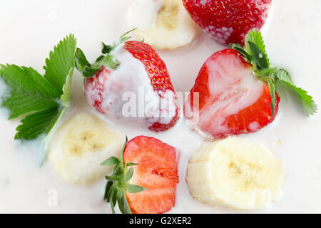Des fraises et des tranches de banane avec de la crème . Banque D'Images