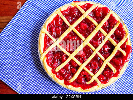 Sweet Cherry pie. frais du four de boulangerie accueil hot cherry pie sur un fond Vichy bleu et blanc. Banque D'Images