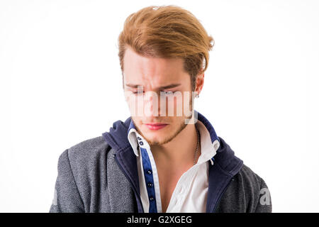 Triste ou inquiet handsome young man looking down, isolated on white Banque D'Images