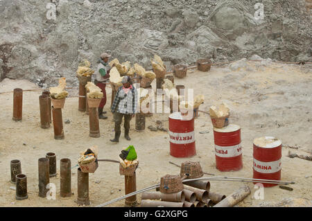 Java, Mt. Les travailleurs de la mine de soufre, l'Ijen avec barils et de paniers remplis de blocs de soufre du volcan Banque D'Images