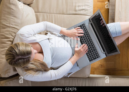 Femme enceinte passe le temps d'un ordinateur portable Banque D'Images