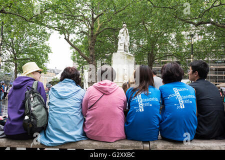 Des gens assis sur un banc de parc à Londres de Leicester Square, England, UK Banque D'Images