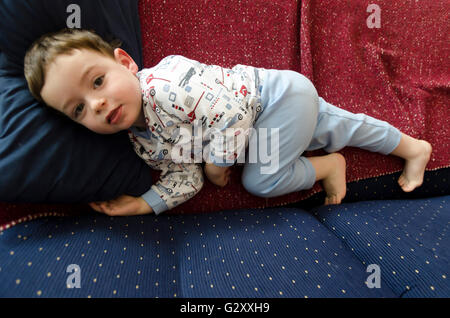 Boy lying on sofa Banque D'Images