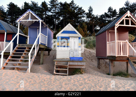 Cabines de plage de couleur vive pendant le coucher du soleil à Wells-next-the-Sea sur la côte nord du comté de Norfolk, en Angleterre, UK. Banque D'Images