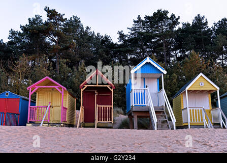 Cabines de plage de couleur vive pendant le coucher du soleil à Wells-next-the-Sea sur la côte nord du comté de Norfolk, en Angleterre, UK. Banque D'Images