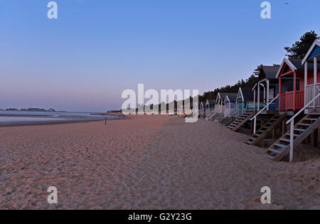 Cabines de plage de couleur vive pendant le coucher du soleil à Wells-next-the-Sea sur la côte nord du comté de Norfolk, en Angleterre, UK. Banque D'Images