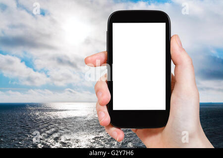 Photographies touristiques travel concept - Mer du Nord en soirée sur smartphone Avec écran découpe avec place vide pour la publicité Banque D'Images