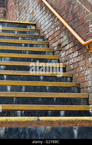 Détail de l'escalier avec la sécurité des threads et de couleur jaune orangée, main courante en acier inoxydable dans un train britannique stati Banque D'Images