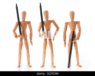 Trois mannequins en bois noir holding pens que des gardes armés. Métaphore d'affaires. Isolated on white with clipping path Banque D'Images