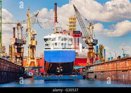 Grand navire sous la réparation sur chantier en cale sèche flottante. Banque D'Images