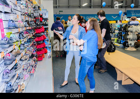 Les clients regarder ladies' chaussures de course en vente dans la section des chaussures de plein air magasin de sport. Banque D'Images