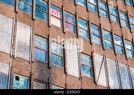 Graffiti sur les fenêtres d'un immeuble de bureaux abandonnés Banque D'Images