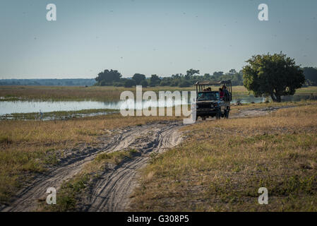 Jeep passagers sur piste sablonneuse regardant river Banque D'Images