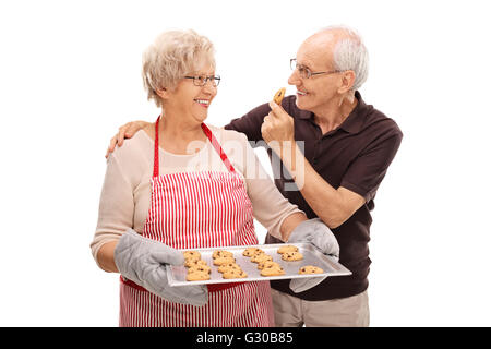 Vieux couple eating cookies au chocolat maison isolé sur fond blanc Banque D'Images