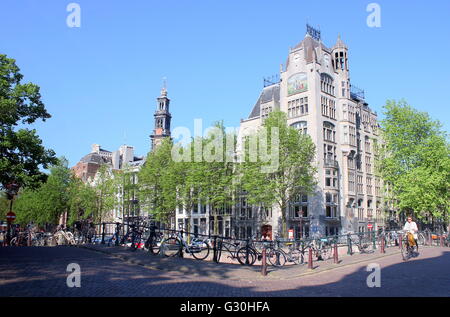 Vélo de l'homme en face de l'Art Nouveau bâtiment Astoria (1905), Keizersgracht canal Leliegracht &,, Amsterdam (ancien siège de Greenpeace) Banque D'Images