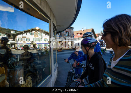 L'hôtel ''Alte Post ' avec Lüftlmalerei reflète dans une boutique pour les cyclistes et les sculptures sur bois en face d'elle, l'Allemagne, l'Oberammergau Banque D'Images