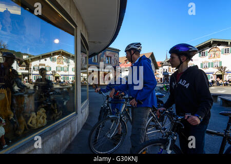 L'hôtel ''Alte Post ' avec Lüftlmalerei reflète dans une boutique pour les cyclistes et les sculptures sur bois en face d'elle, l'Allemagne, l'Oberammergau Banque D'Images