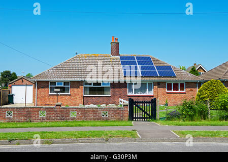 Bungalow semi-détaché, la moitié du toit avec des panneaux solaires, la moitié sans l'Angleterre, Royaume-Uni Banque D'Images