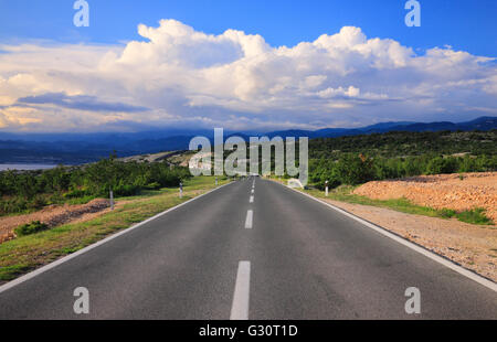 Route asphaltée vide avec des nuages au-dessus, l'île de Krk en Croatie Banque D'Images