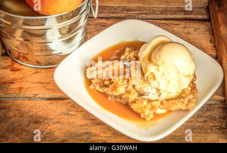 Croquant à la mode. Croustade aux pommes fraîchement cuit au four avec de la crème glacée à la vanille et sauce caramel maison. Banque D'Images