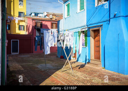 Blanchisserie accroché sur les lignes en face de maisons de Burano. Banque D'Images